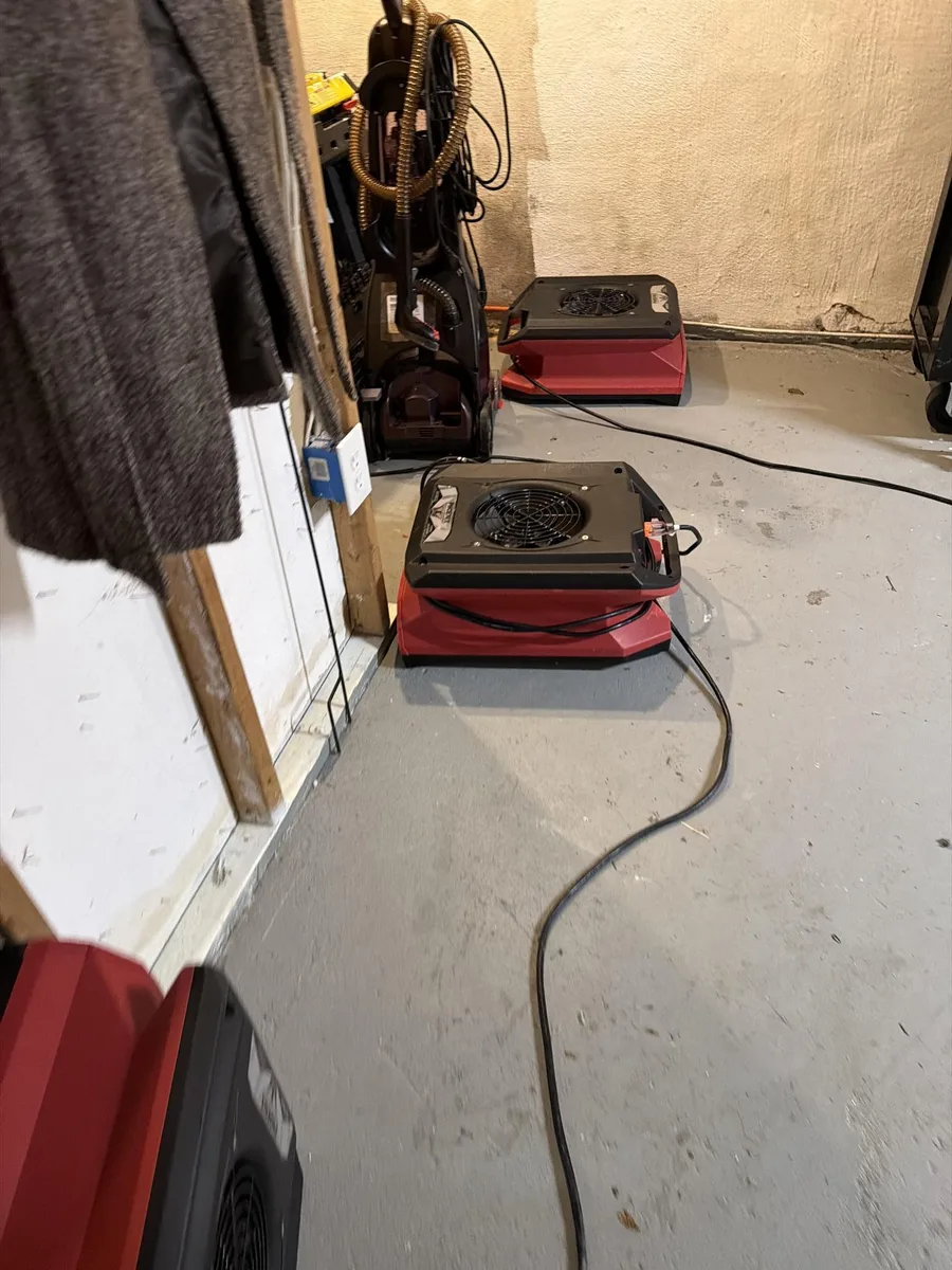 Air movers along the laundry-area floor during cleanup after an Upper Moreland water heater failure
